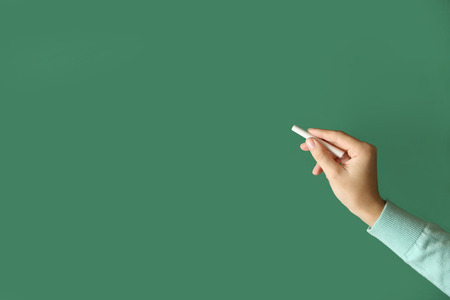 Female hand writing on blackboard with chalk, close upの写真素材