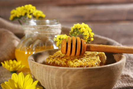 Honeycomb with dipper and jar of honey on sackcloth, close-upの写真素材