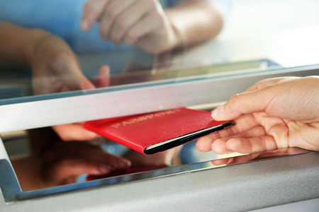 Woman buying tickets with passport at box officeの写真素材