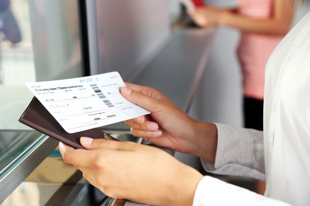 Woman buying tickets with passport at box officeの写真素材