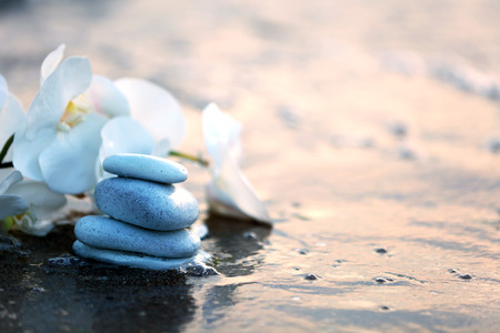 Spa stones with flowers on sea beach outdoorsの写真素材