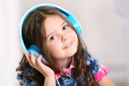 Little girl with headphones in the room, close upの写真素材