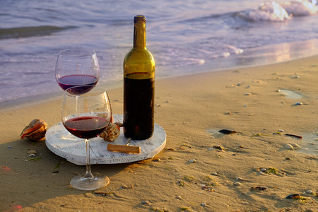 Wine bottle and glasses on the seashoreの写真素材