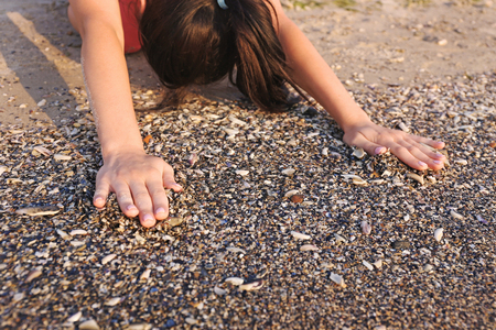 Beautiful girl practicing yoga on the sand in the morning, close upの写真素材