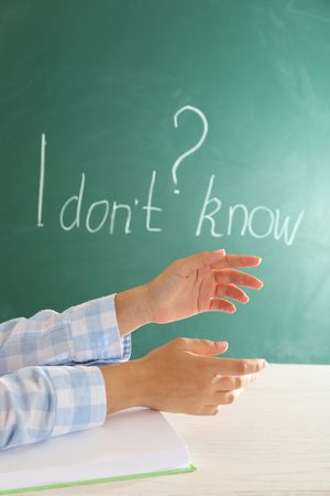 Women hands with book on blackboard background の写真素材