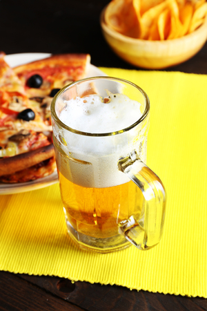 Sliced pizza served with beer on wooden tableの写真素材