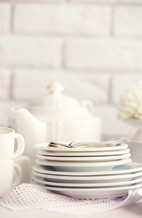 Clean dishes on table on brick wall backgroundの写真素材