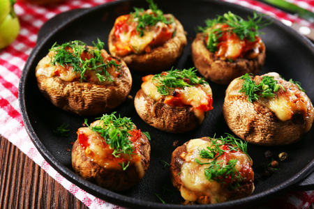 A frying pan with stuffed mushrooms on the tableの写真素材