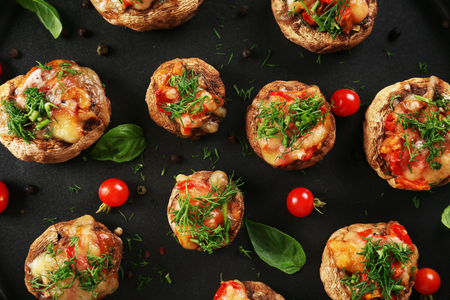 A frying pan with stuffed mushrooms and vegetables on the table, close-up, top viewの写真素材