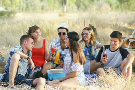 Young hippie people relaxing in the forest outdoorsの写真素材