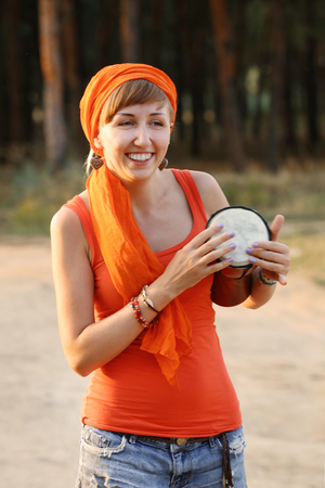Bright smiling girl with jembe in the forest outdoorsの写真素材