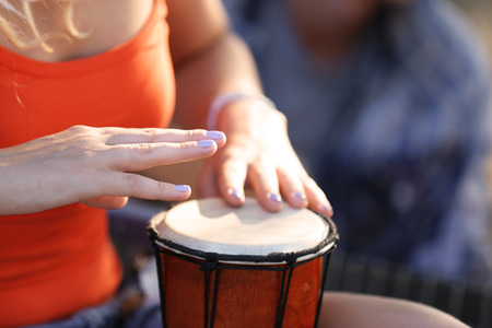 Females hands play a drum, close up