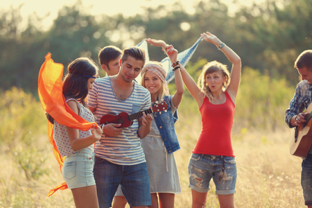 Carefree friends with guitars have fun, outdoorsの写真素材