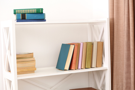 Books on shelves on white wall backgroundの写真素材