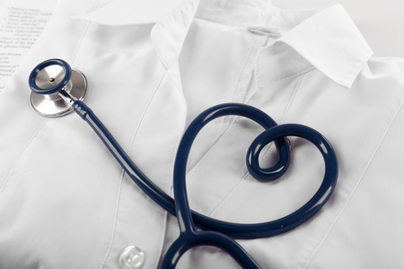 Heart shaped blue stethoscope, medical record and uniform, close upの写真素材