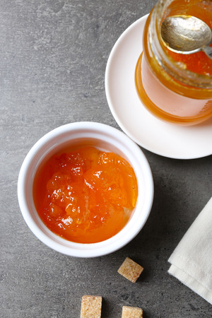 Tasty jam in the jar and bowl, crackers and fresh buns close-upの写真素材