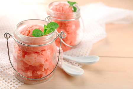 Watermelon ice cream in glass jars  on color wooden backgroundの写真素材