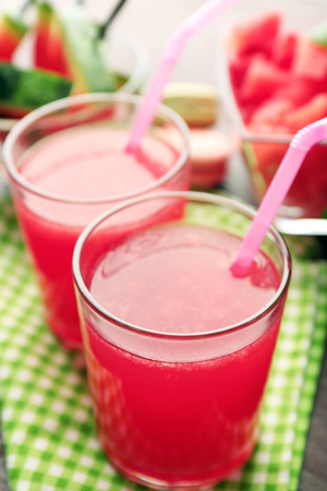 Cold watermelon drinks in glasses, on wooden table backgroundの写真素材