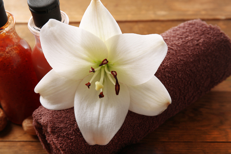 Close up of lily flower with towel and cosmetic bottlesの写真素材