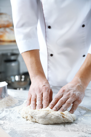 Making dough by male hands at bakeryの写真素材