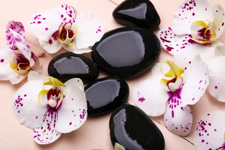 Orchid and zen stones on wooden background close-upの写真素材