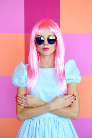 Portrait of beautiful woman with pink hairstyle on bright wall backgroundの写真素材