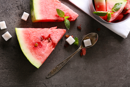 Sliced watermelon in metal bowl with sugar on grey background, close upの写真素材