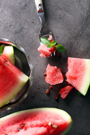 Sliced watermelon in metal bowl on grey background, close upの写真素材
