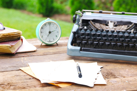 Vintage black typewriter on wooden table, outdoorsの写真素材