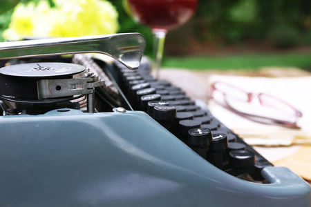Vintage black typewriter on decorated wooden table, outdoors, close upの写真素材