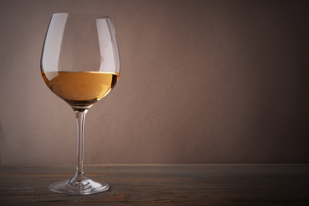 Glass of white wine on wooden tableの写真素材
