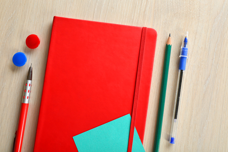 Red notebook with stationery on wooden backgroundの写真素材