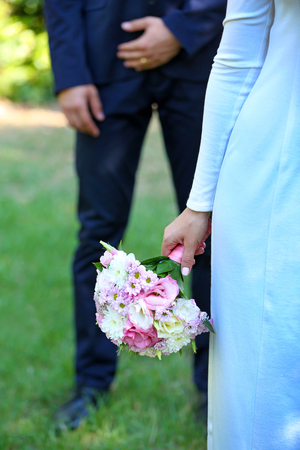 Bride with wedding bouquet and groom on nature backgroundの写真素材
