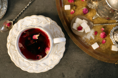Cup of rose tea with sugar on wooden tableの写真素材