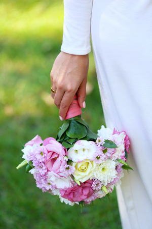 Beautiful wedding bouquet in hands of brideの写真素材
