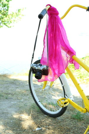 Old bicycle with camera and pink scarf, outdoorsの写真素材