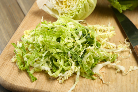 Cut savoy cabbage on wooden cutting boardの写真素材