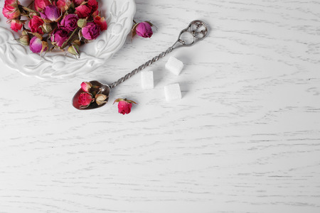 Tea rose flowers on plate on wooden tableの写真素材