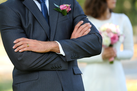 Groom  and bride with wedding bouquet on nature backgroundの写真素材