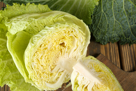 Cut savoy cabbage on wooden cutting board closeupの写真素材
