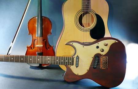Electric and acoustic guitars, violin on blue background