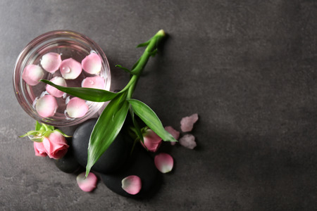 Spa composition of stones, flowers and petals, on grey backgroundの写真素材