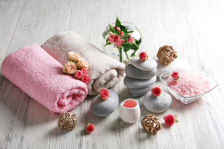 Composition of flowers, salt and stones on white wooden background, in spa salonの写真素材