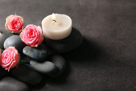 Spa composition of candles,  stones and flowers, on grey backgroundの写真素材