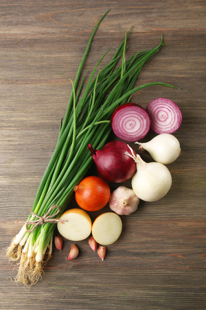 Fresh different onions with garlic on wooden backgroundの写真素材