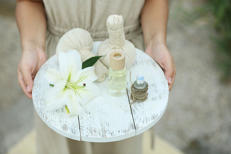 Female hands with tray of spa products, outdoorsの写真素材