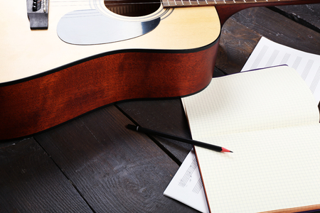 Guitar and music sheets on wooden backgroundの写真素材
