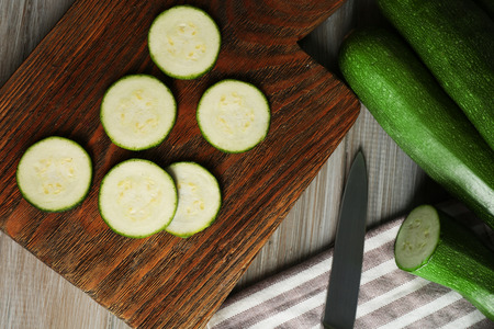 Fresh sliced zucchini on cutting board, on wooden backgroundの写真素材