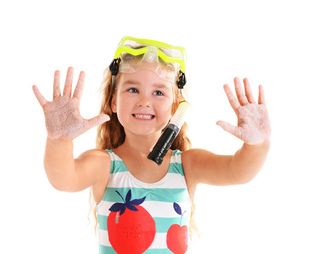 Happy little girl in blue striped swimsuit with diving mask poses on white backgroundの写真素材