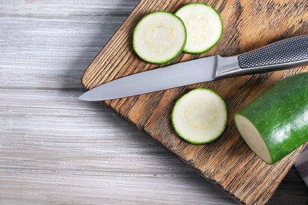 Fresh sliced zucchini on cutting board, on wooden backgroundの写真素材